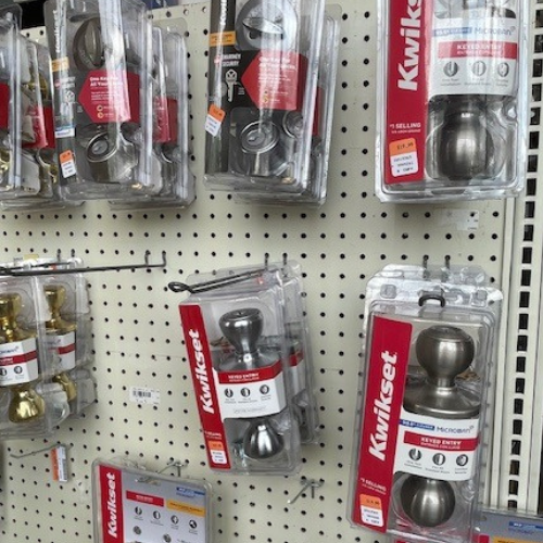 Display of Kwikset products, including interior and exterior door knobs.