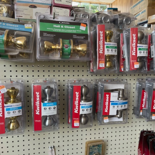 Display of Kwikset products, including various door knobs and handles.