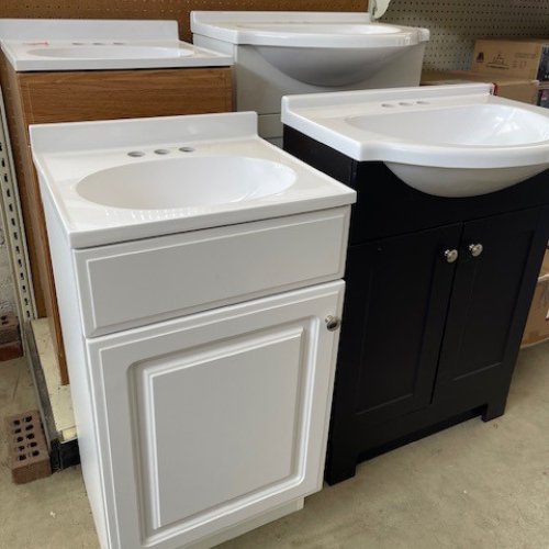 Display of vanities in a range of colors, including white, wood, and black, with options featuring one or two cabinet doors.